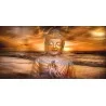 Cuadro de Buda transparente sobre puesta de sol en paisaje marino.