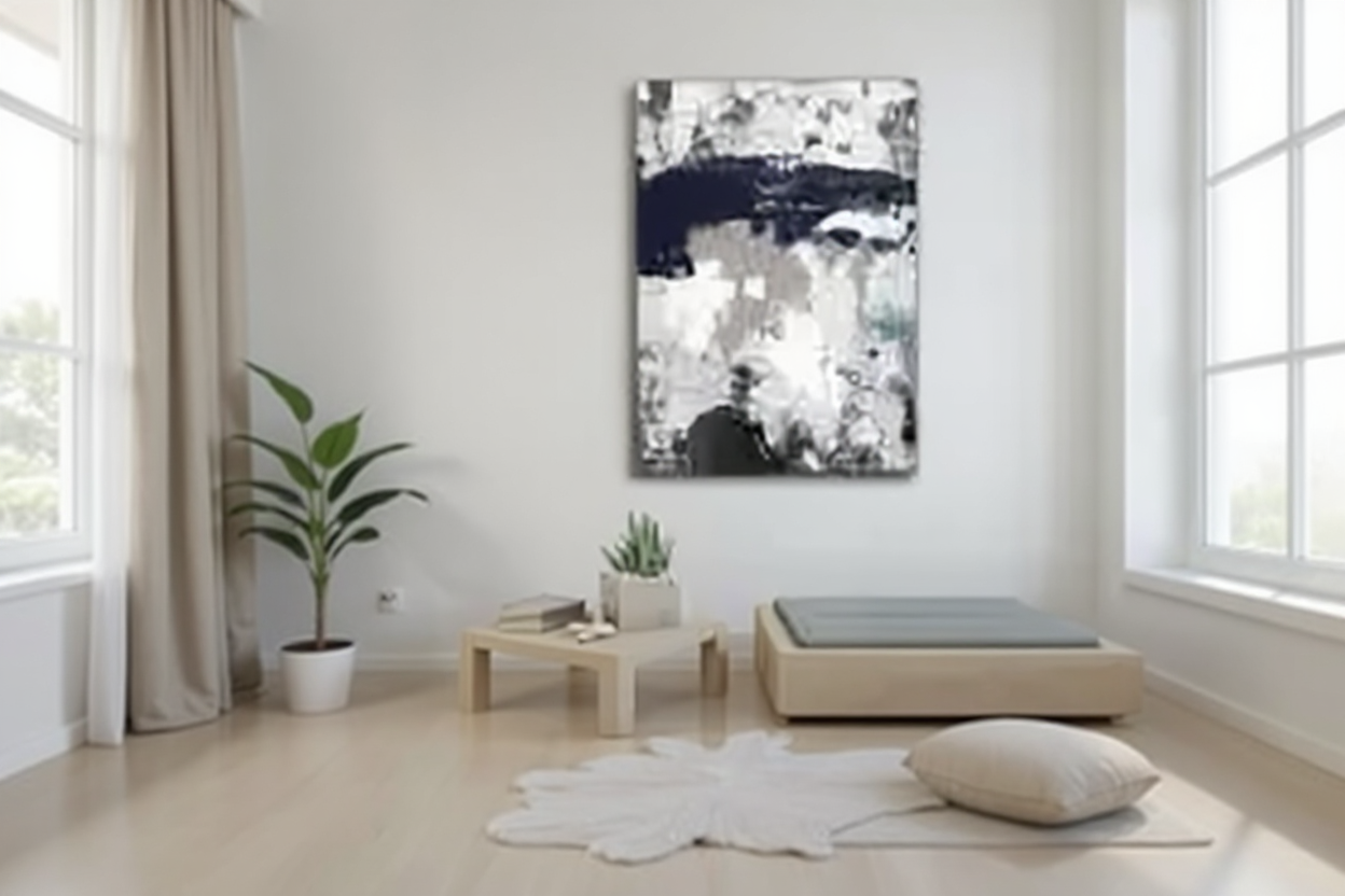 Cuadro abstracto moderno en azul marino y blanco colgado sobre rincón de meditación minimalista en dormitorio sereno