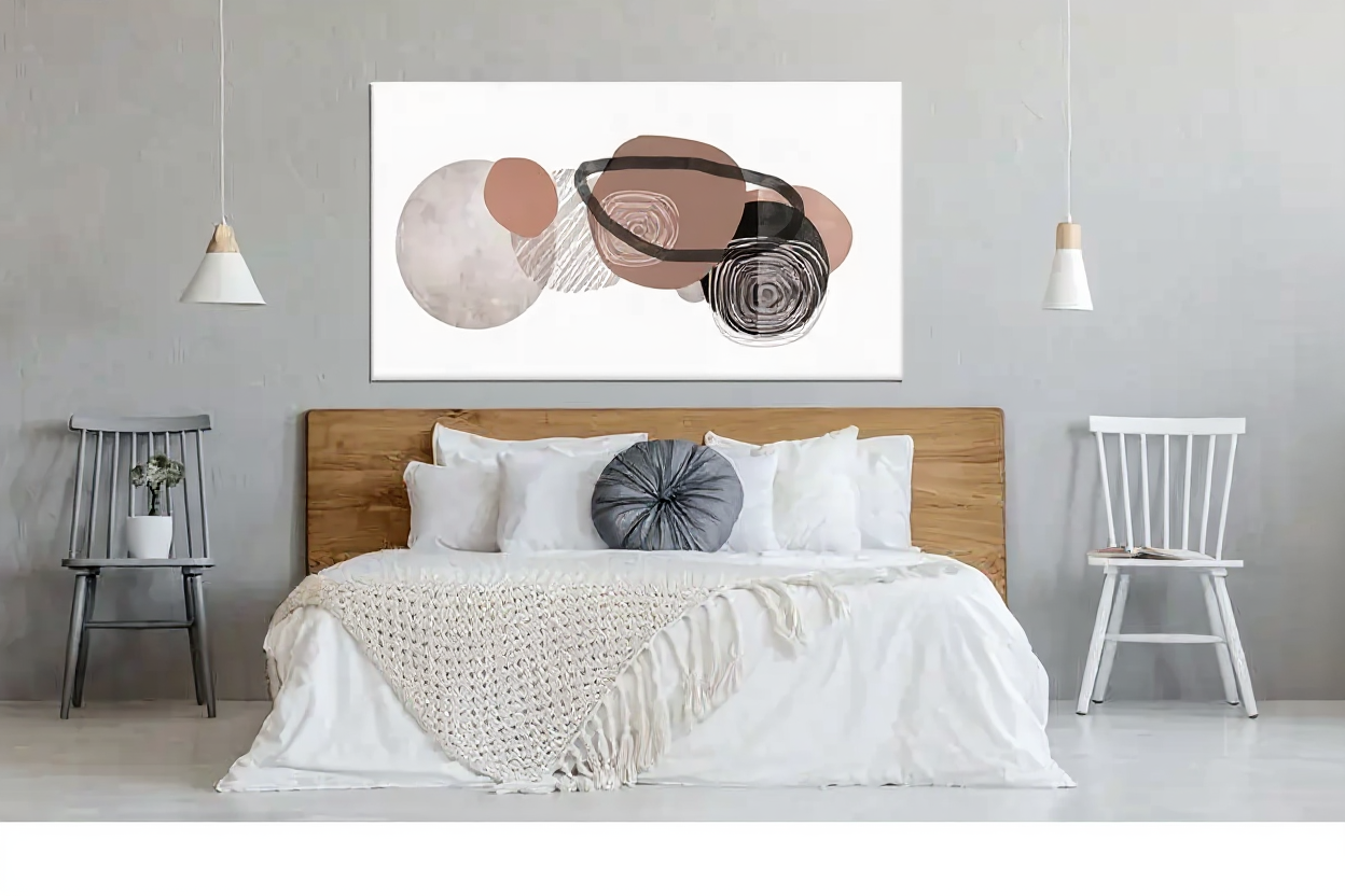 Cuadro abstracto geométrico colgado sobre cama con ropa blanca en dormitorio nórdico