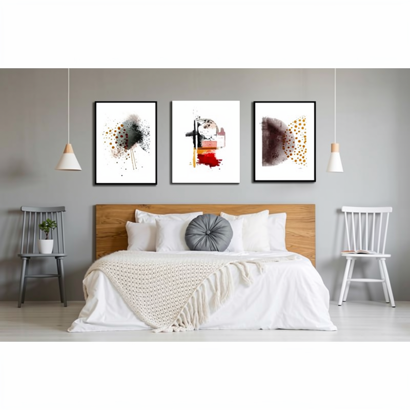 Tres cuadros abstractos con marcos negros colgados sobre la cama en perfecta composición