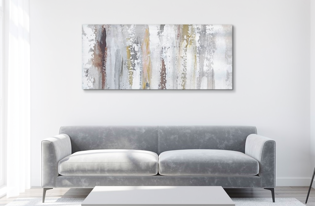 Cuadro abstracto en tonos grises y dorados sobre sofá gris en salón moderno